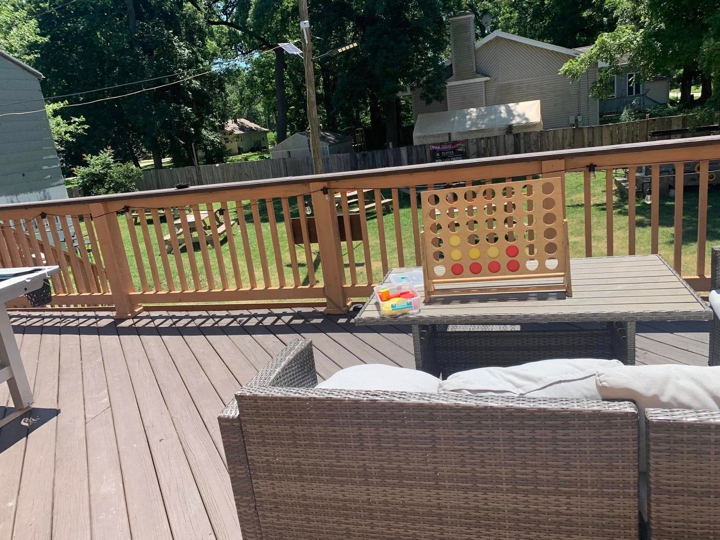 Outdoor deck with seating, games, and a view of the yard